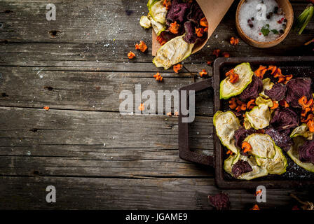 Bio-Ernährung essen. Die vegane Ernährung. Getrocknetes Gemüse. Hausgemachte Chips aus Rüben, Karotten und Zucchini. Auf alten rustikalen Holztisch mit frischem Gemüse Stockfoto