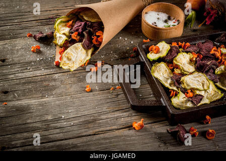 Bio-Ernährung essen. Die vegane Ernährung. Getrocknetes Gemüse. Hausgemachte Chips aus Rüben, Karotten und Zucchini. Auf alten rustikalen Holztisch mit frischem Gemüse Stockfoto