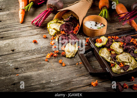 Bio-Ernährung essen. Die vegane Ernährung. Getrocknetes Gemüse. Hausgemachte Chips aus Rüben, Karotten und Zucchini. Auf alten rustikalen Holztisch mit frischem Gemüse Stockfoto