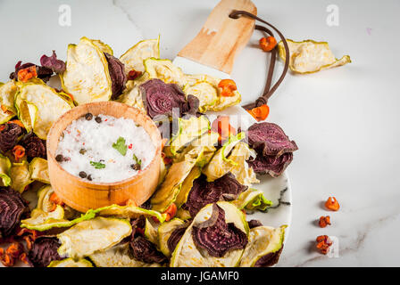 Bio-Ernährung essen. Die vegane Ernährung. Getrocknetes Gemüse. Home-Chips aus Rüben, Karotten und Zucchini. Auf einem weißen Marmortisch mit frischem Gemüse. Kopie Stockfoto