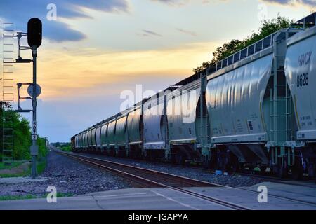 Bei Reisen in Richtung Westen, Güterzug aus Chicago, wie es in den letzten Licht des Tages Köpfe beim Durchlaufen durch Maple Park, Illinois, USA. Stockfoto