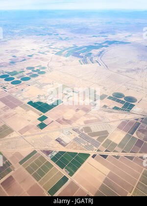 Felder von Arizona, USA, von oben gesehen, mit ein paar Nachbarschaften in der Stadt von Maricopa. Stockfoto