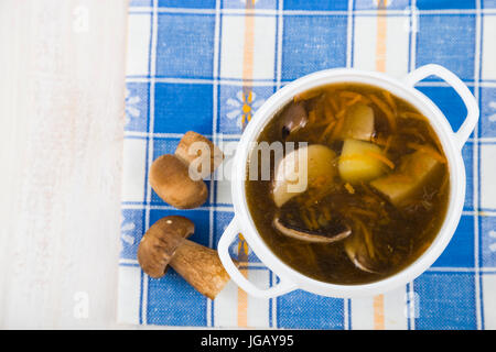 Suppe von Waldpilzen auf einem Holztisch. Köstliche weiße Pilze in einer Platte. Stockfoto