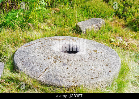 Verlegung auf dem Rasen am Hang Derbyshire aufgegeben ist eine alte, fast fertig, Mühlstein. Stockfoto