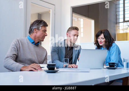 Konzentrierte sich junge Unternehmer mit einem Laptop zusammen in einem Büro Stockfoto