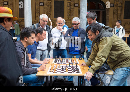 Gruppe der Männer spielen Schach, während andere gerade im Hof des La Vieille Bourse (alte Börse) in Lille, Frankreich Stockfoto