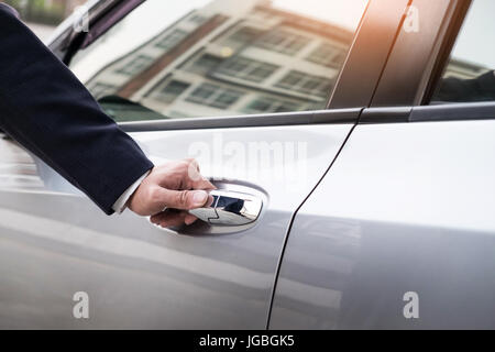 Chauffeur-s Hand am Griff. Nahaufnahme des Mannes in Abendgarderobe eine Passagier Autotür zu öffnen. Stockfoto
