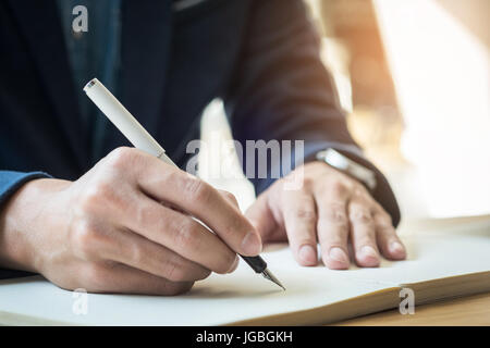Geschäftsmann in einem Dokument zu schreiben. Konzentrieren Sie sich auf die Spitze des Stiftes. Stockfoto