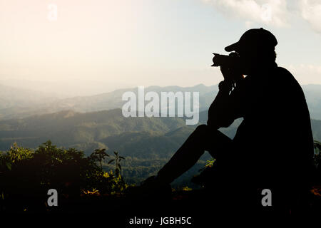 Silhouette von einem jungen, die gerne reisen und Fotografen, die Bilder von der schönen Momente während der Sonnenuntergang, Sonnenaufgang und Berg. Stockfoto