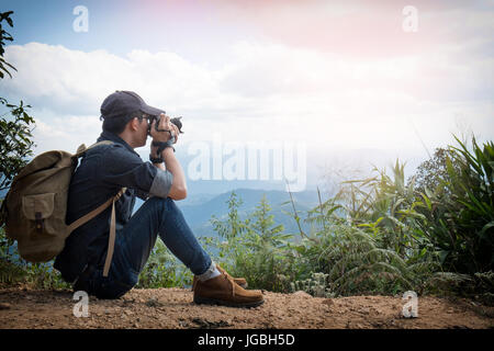 Junge professionelle Travrler Mann mit Kamera schießen im Freien, fantastische Berglandschaft. Stockfoto
