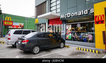 Manila, Philippinen - 20. Dezember 2015. Autos parken auf Straße in der Innenstadt von Manila, Philippinen. Stockfoto