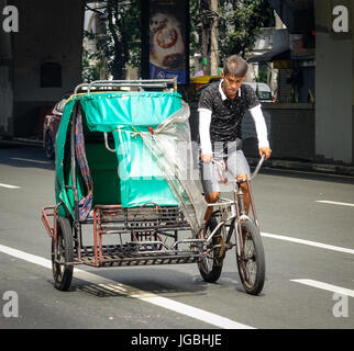 Manila, Philippinen - 20. Dezember 2015. Ein Mann mit Fahrradrikscha auf Straße in Manila, Philippinen. Manila ist mit 1.780.148 Personen im Jahr 2015 eines der meisten Bevölkerung Stockfoto