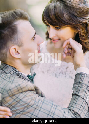 Die Seite close-up Portrait streichelte die Wange der lächelnde Braut Bräutigam. Stockfoto