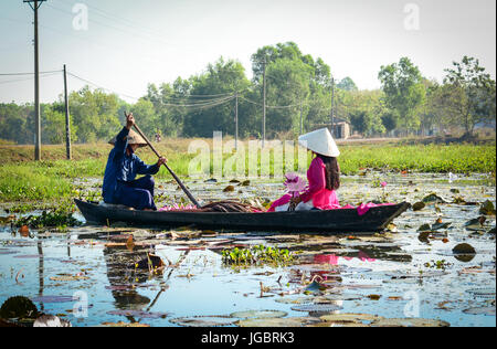 Tay Ninh, Vietnam - 4. Februar 2016. Menschen mit kegelförmiger Hut Ruderboot und Ernte Blumen auf der Seerose-See in Tay Ninh, Südvietnam. Stockfoto