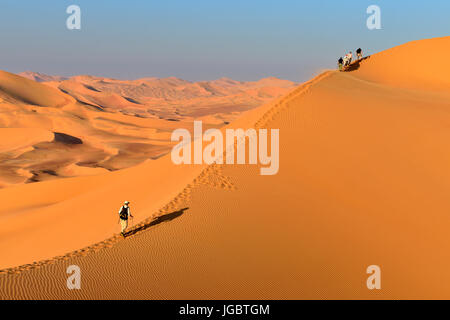 Touristen in den Dünen wandern, Rub Al Khali Wüste, Khali, Dhofar, Oman Stockfoto