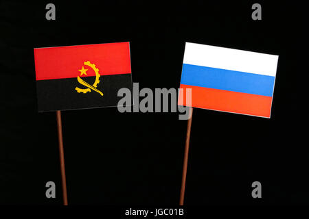 Angola Fahne mit russischer Flagge auf schwarzem Hintergrund isoliert Stockfoto