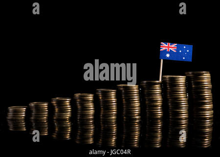 Australische Flagge mit Menge von Münzen auf schwarzem Hintergrund isoliert Stockfoto