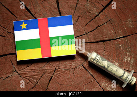 Zentralafrikanische Republik Flagge auf einem Baumstumpf mit Spritze Einspritzen Geld in Flagge Stockfoto