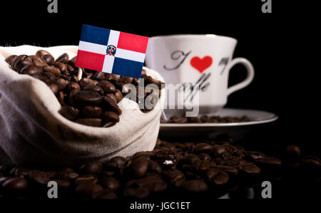 Dominikanische Republik Flagge in einer Tasche mit Kaffeebohnen auf schwarzem Hintergrund isoliert Stockfoto