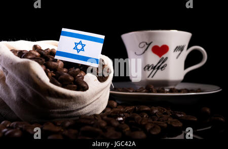 Israelische Flagge in einer Tasche mit Kaffeebohnen auf schwarzem Hintergrund isoliert Stockfoto