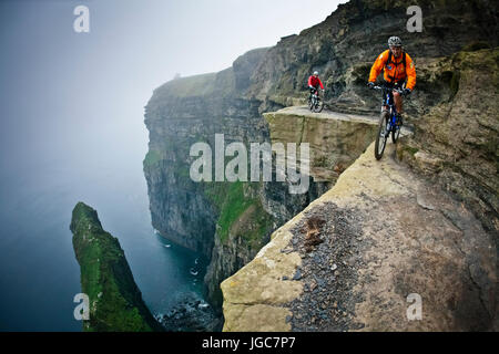 Professionelle Mountainbiker Hans Rey und Steve Peat reiten die Cliffs of Moher Stockfoto