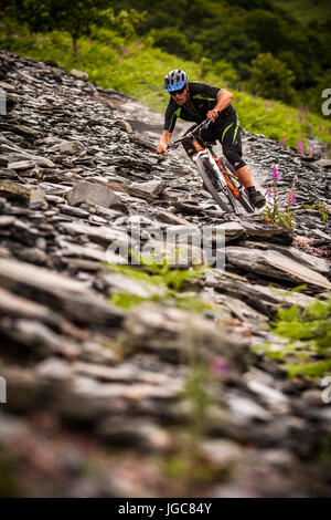 Ein Mountainbiker durchfährt ein altes Schieferbergwerk in Nord-Wales Stockfoto