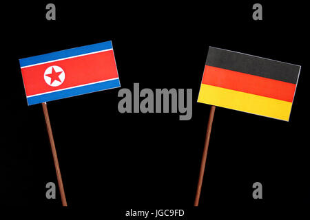 Nordkoreanischer Flagge mit deutscher Flagge auf schwarzem Hintergrund isoliert Stockfoto