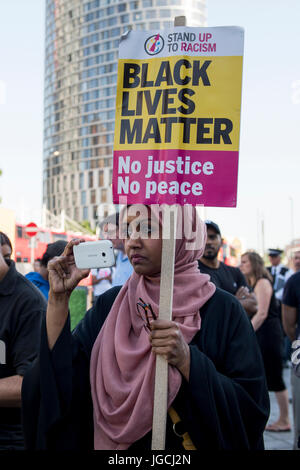 London, UK. 5. JULI 2017. "STOP ACID ATTACKS" Notfall Protest vor dem Bahnhof Stratford in East London. Demonstranten versammelt, um gegen die jüngsten Säureangriffe und zunehmende Islamophobie zu protestieren. Eine junge muslimische Frau hält ein Plakat "Black lebt Materie" zu lesen, während eine Videoaufnahme des Protestes mit ihrem Handy.  Bildnachweis: ZEN - Zaneta Razaite / Alamy Live News Stockfoto