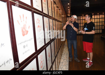 (170706)--NANJING, 6. Juli 2017 (Xinhua)--Wu Xianbin (L) führt eine veteran Handabdruck Wand in College-Student Yang Yongchang an der Anti-japanischen Krieg-Heimatmuseum Nanjing in Nanjing, der Hauptstadt der ostchinesischen Provinz Jiangsu, 24. Juni 2017. Wu Xianbin, Nanjing ansässige Geschäftsmann, eröffnet im Jahr 2006 ein privat investiert Ausstellung Hall von Nanjing Anti-japanischen Krieg Heimatmuseum, die seine persönliche Sammlung von historischen Fotos, japanischen militärischen Karten und sonstiges Erbe des Krieges hält. Jetzt, mit der Sammlung von mehr als 5.700 Kriegszeit Denkmäler, 40.000 Bücher und Dokument Stockfoto