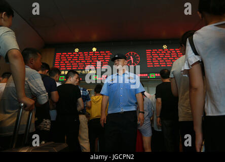 (170706)--WUHAN, 6. Juli 2017 (Xinhua)--ist ein Polizist im Dienst an der Kasse des Wuhan Bahnhofs in Wuhan, Hubei Provinz Zentral-China, 6. Juli 2017. Mehr als 100 Züge wurden angehalten, nach starken Regenfällen Liuyanghe Tunnel entlang der Hochgeschwindigkeits-Bahnstrecke zwischen Peking und Guangzhou überflutet. Mehr als 30.000 Fahrgäste blieben am Bahnhof gestrandet.  (Xinhua/Zhao Jun) (Mcg) Stockfoto