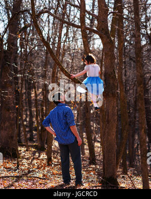 Vater seiner Tochter sitzt in einem Baum zu betrachten Stockfoto