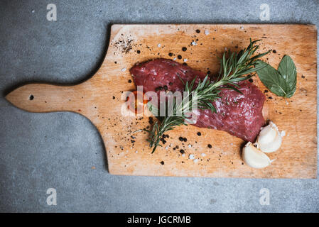 Draufsicht auf Steak mit Knoblauch und Kräutern Stockfoto