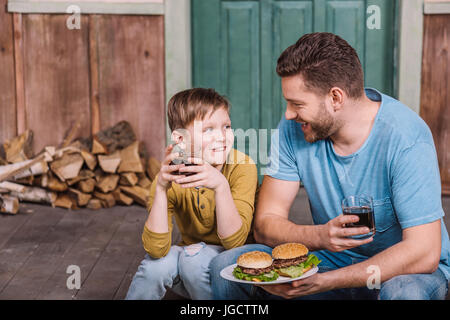 Porträt der glückliche Vater und Sohn Essen hausgemachte Burger Stockfoto