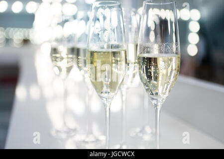 Champagner Gläser auf weißem Hintergrund in hellen Lichtern. Fashion-Show backstage Stockfoto