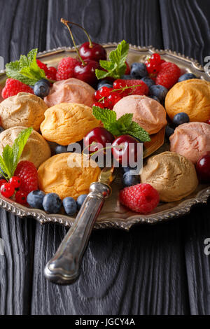 Bunte Kekse mit Himbeeren, Erdbeeren, Kirschen und Johannisbeeren Nahaufnahme auf dem Tisch. Vertikal Stockfoto