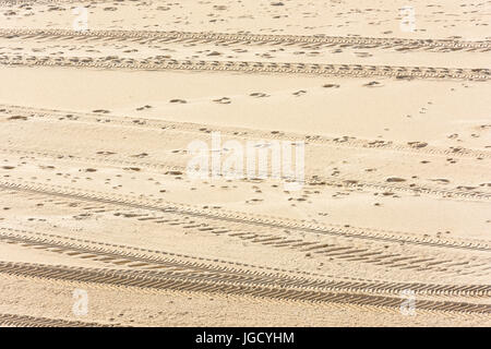 Spuren von Pkw-Reifen auf dem Sand als Hintergrund Stockfoto