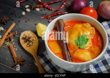 Nahaufnahme Huhn Massaman Curry mit Kraut auf hölzernen Hintergrund, thailändische Spezialitäten Stockfoto