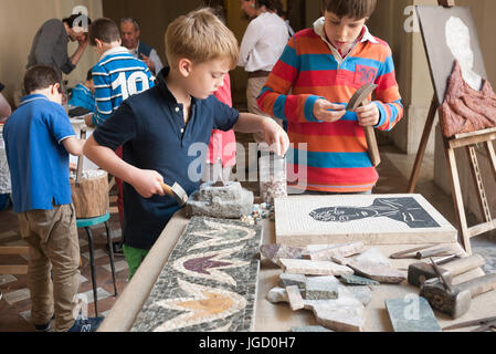 Kinder lernen, wie man ein Steinmosaik machen Stockfoto