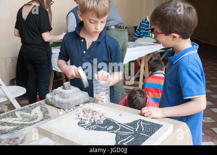 Kinder lernen, wie man ein Steinmosaik machen Stockfoto