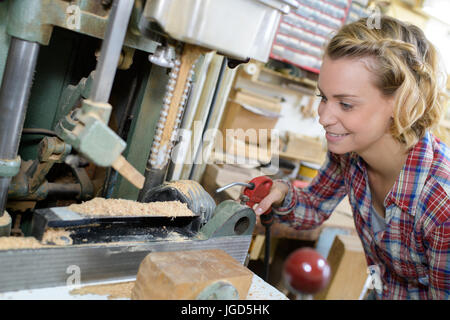 Frau arbeitet auf Bohrmaschinen in der Schlosserei Stockfoto