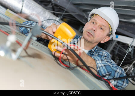 Elektriker arbeiten an einem Stromzähler Stockfoto