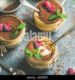 Hausgemachte Tiramisu in einzelnen Gläsern mit Himbeeren und frischer Minze Stockfoto