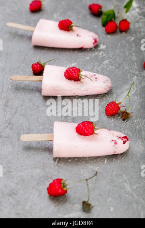 Himbeer Eis auf grauem Hintergrund. Drei hausgemachtes Eis am Stiel. Stockfoto