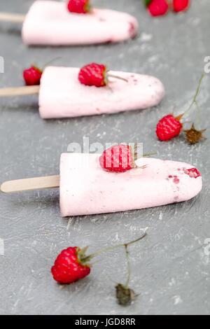 Himbeer Eis auf grauem Hintergrund. Drei hausgemachtes Eis am Stiel. Stockfoto