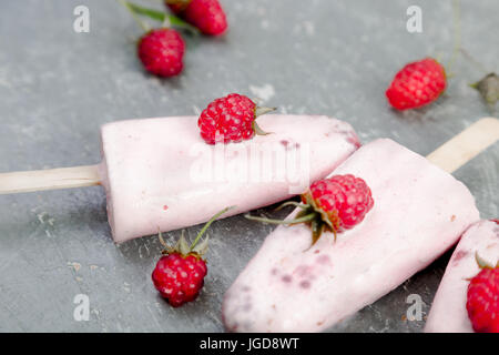 Himbeer Eis auf grauem Hintergrund. Drei Eis am Stiel. hausgemacht. Stockfoto