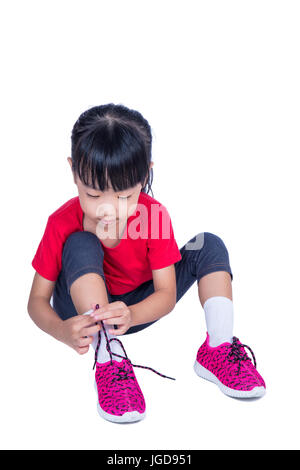 Asiatische chinesische Mädchen binden ihre Schuhe in isolierten weißen Hintergrund Stockfoto