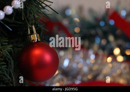 Christbaumkugel Weihnachtsdekoration, gegen eine Out of Focus Silber Flitter Hintergrund Stockfoto