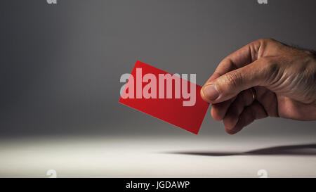 Rot Visitenkarte in die Hand eines Mannes, Studio Closeup. Stockfoto