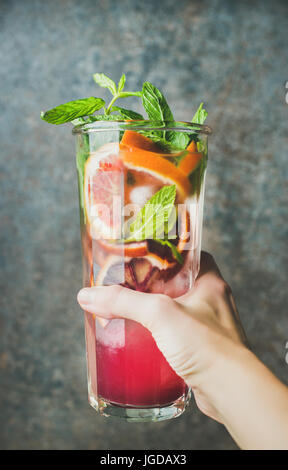 Zarte Frauenhand mit Glas hausgemachten Blutorange citrus Limonade Stockfoto