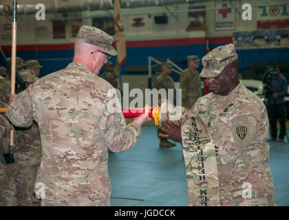 Oberst Stephen M. Bousquet, Kommandeur der 369th Sustainment Brigade von der New York Army National Guard und Command Sergeant Major Anthony Mclean, eingetragenen Berater von der 369th Fall die Brigade Farben während einer Übertragung von Autorität Zeremonie im Camp Arifjan, Kuwait, 26. Juni 2017. 369th SB aufgegeben Befehl Sustainment Operationen der 371. Sustainment Brigade aus Ohio National Guard. (Foto: US-Armee Sgt. Jeremy Bratt) Stockfoto